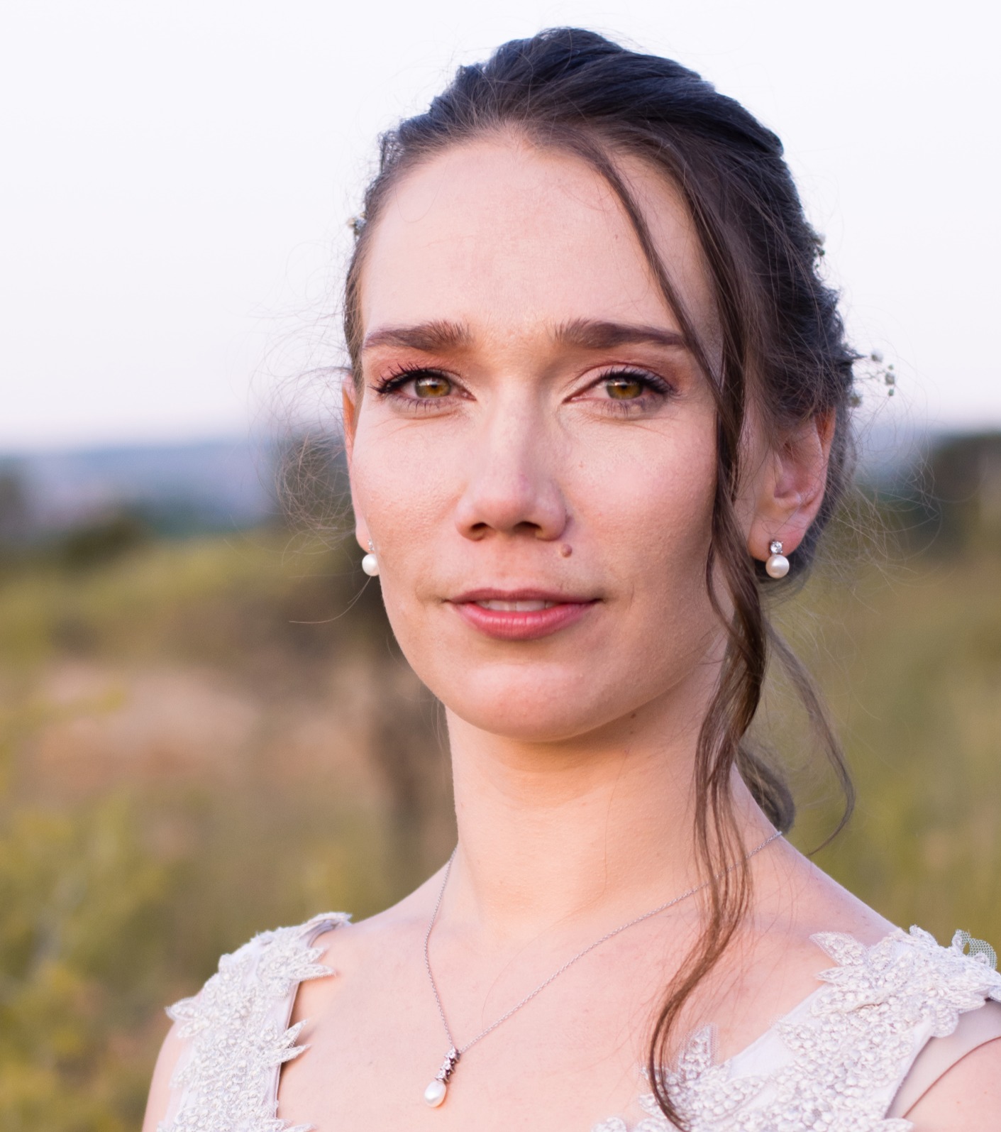 A photo of a woman wearing a white dress in a field.